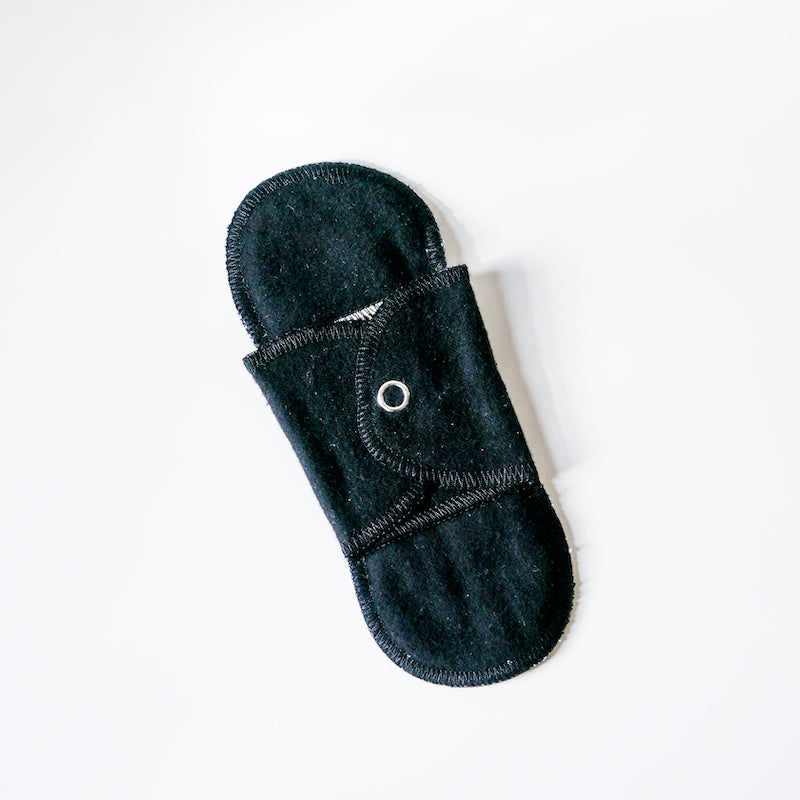 Black reusable menstrual pad on a white background