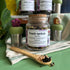 Jar of Peach Apricot black tea with a wooden spoon on a green surface