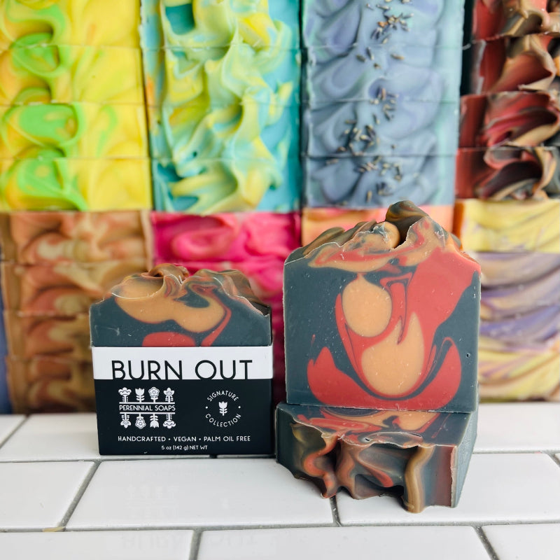 The perennial bar soap in the sent Burn Out in front of a stack of bar soaps