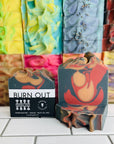The perennial bar soap in the sent Burn Out in front of a stack of bar soaps