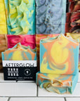 Perennial Soaps Afterglow bar in front of a stack of bar soaps.