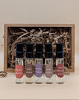 A discovery set featuring five samples of refillable plant based perfumes. The small glass vials have a black lids and each are labeled with a sticker. The gift box is brown paper and filled with craft paper. 