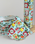 A stack of the Planet B Paperless Towels in the Jams & Jars pattern next to a roll of the same pattern on a towel roll holder. 