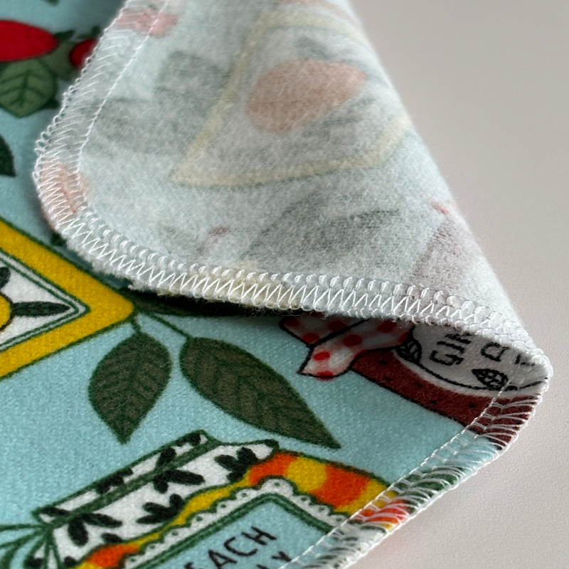 A close up of a corner of the Jars & Jams paperless towel's reverse side and the fuzzy cotton flannel texture. 
