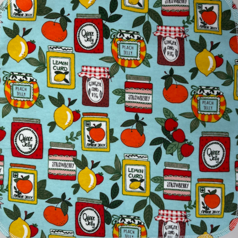 The Jams and Jars Paperless Towel Pattern featuring jars of jams and citrus fruits on a blue background. 
