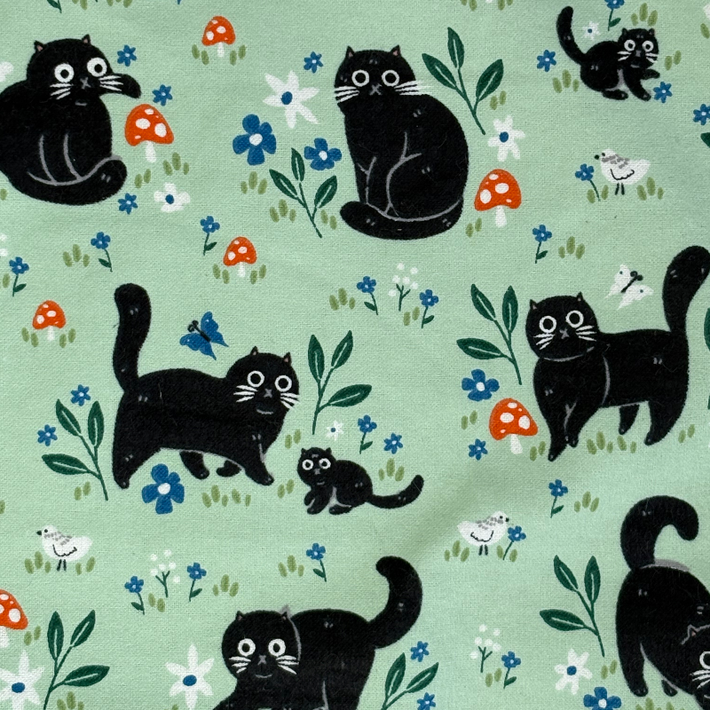 The Black Cat patterned paperless towel featuring a black cat playing with mushrooms and bugs on a green background. 