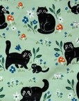 The Black Cat patterned paperless towel featuring a black cat playing with mushrooms and bugs on a green background. 