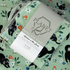 A stack of the Black Cat Patterned Paperless towels with the same patterned paperless towel in the background. 
