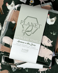 A stack of the Farm Friends Patterned Paperless towels with the same patterned paperless towel in the background. 