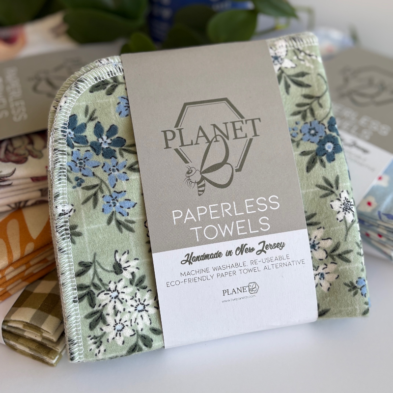 A pack of the Floral Sage patterned Paperless towels, featuring white and blue floral illustrations on a green background. 
