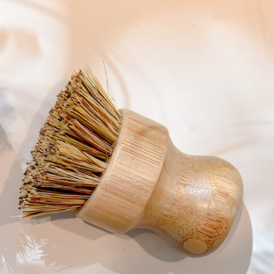 The Zefiro Pot Brush, made from beechwood with natural bristles and a rounded ergonomic handle for easy gripping, rests on a white surface.