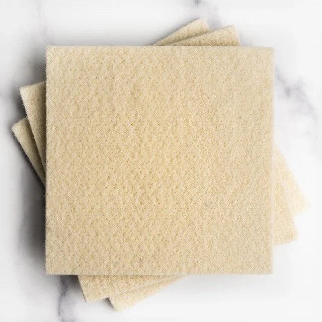 A stack of wool scrubbers on a marble surface. 