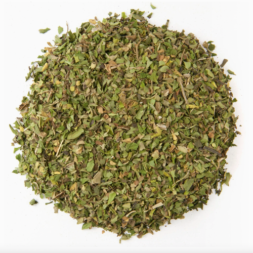 A circular pile of dried, chopped green herbs on a white background resembles the classic Peppermint Herbal Tea leaves from Loose Leaf Tea Co.