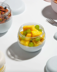 bowl of mango and grapes on white backdrop