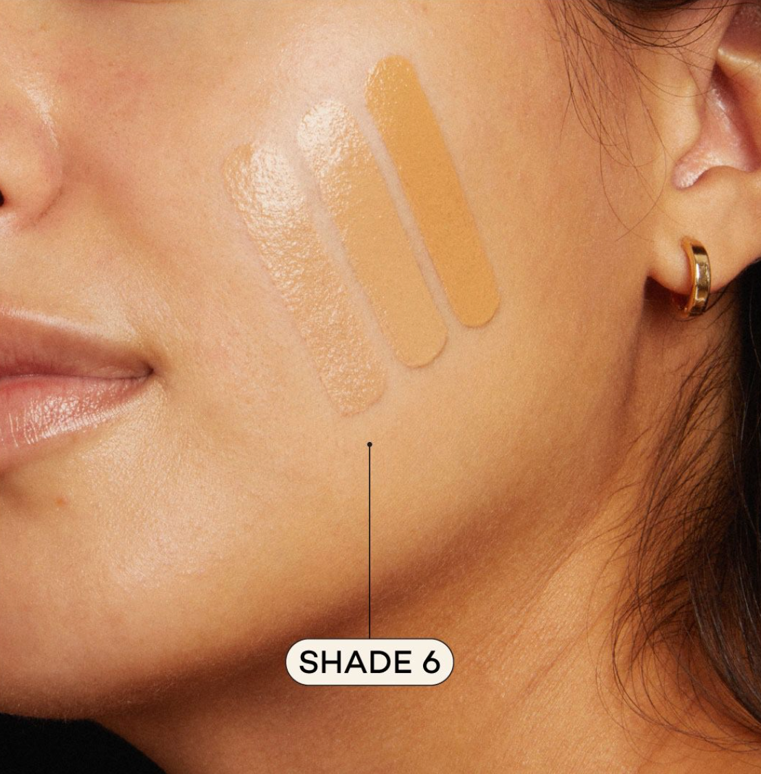 Medium skinned woman featuring medium foundation swatched on cheek