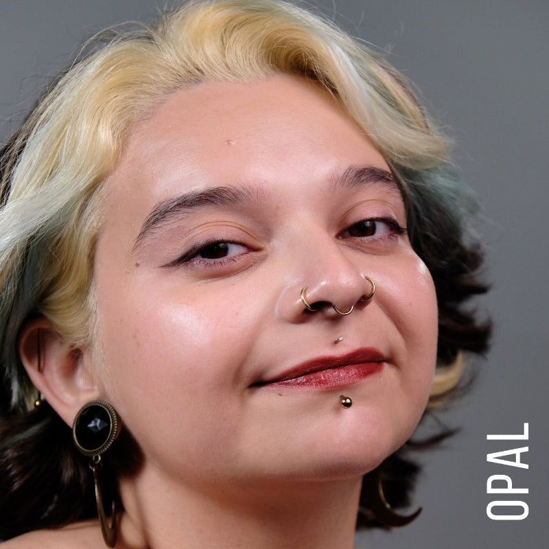 A model wearing the skin tint in the shade opal. 
