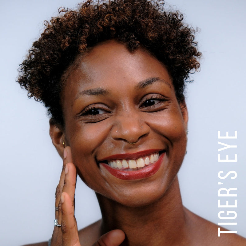 A model wearing the skin tint in the shade Tiger's Eye.