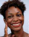A model wearing the skin tint in the shade Tiger's Eye.
