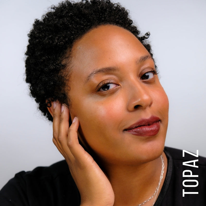 A model wearing the skin tint in the shade topaz.