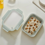 Gray food container with oatmeal and almonds on a light surface