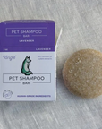 A purple Tangie Pet shampoo bar box with the shampoo bar in lavender next to it on a textured fabric background. 