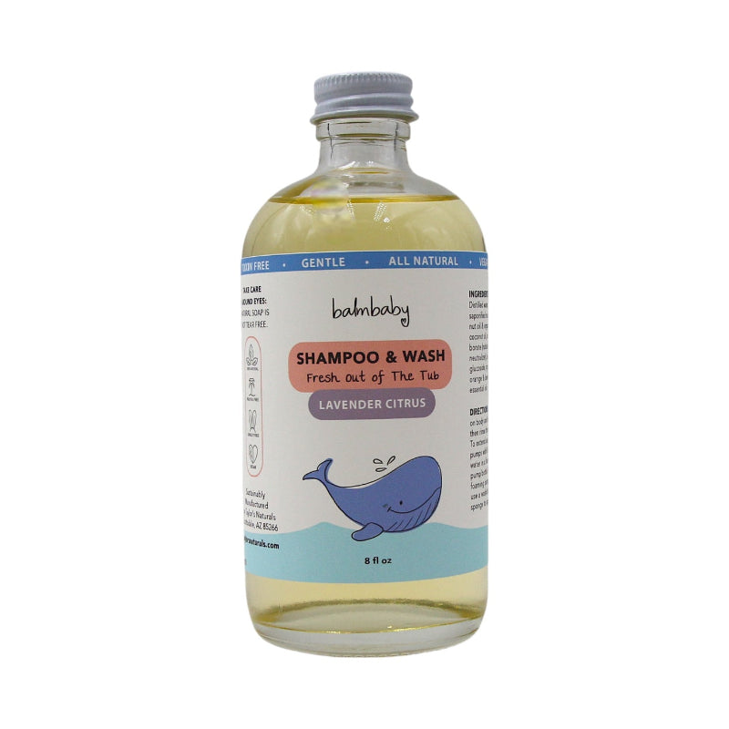A clear glass bottle of Taylor's naturals refillable baby wash. The bottle is full of gentle body wash/ shampoo, the bottle has a happy whale on it. 
