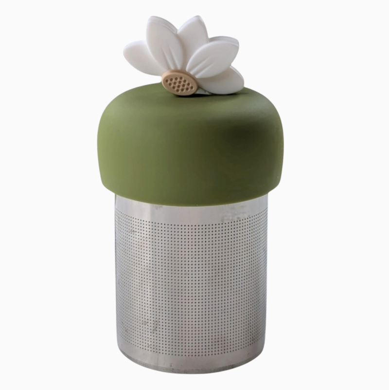 The Teany Tiny Kitchen Floating Tea Infuser features a cylindrical metal design with a green silicone lid and white lotus flower, providing an innovative and effortless way to steep your tea.