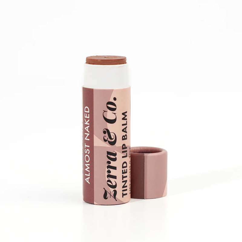 A Zerra & Co. Tinted Lip Balm in Almost Naked with the cap off shows the warm nude balm inside. 