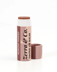 A Zerra & Co. Tinted Lip Balm in Almost Naked with the cap off shows the warm nude balm inside. 