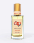 Square glass bottle with gold top and tan label tobacco and driftwood hair and body dry oil on white background. 
