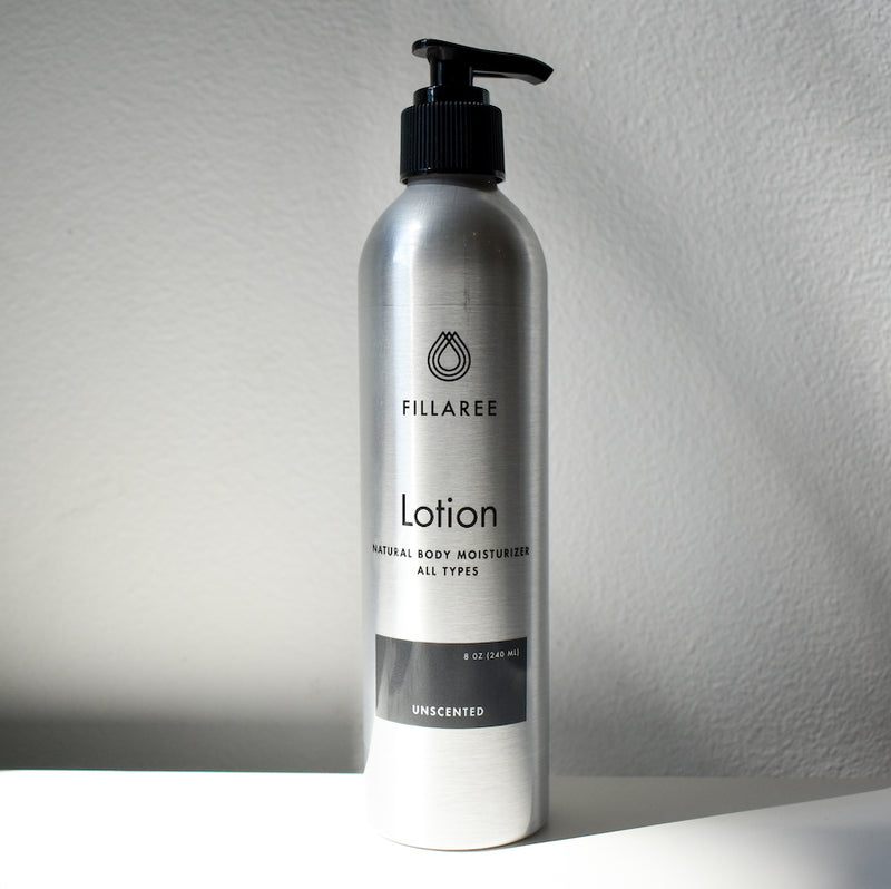 metal bottle of lotion on white backdrop