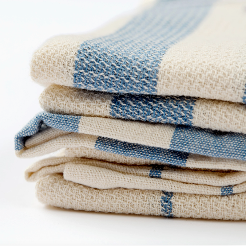 Stack of folded checkered towels in blue and beige on a white background