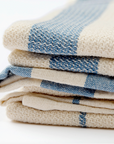 Stack of folded checkered towels in blue and beige on a white background