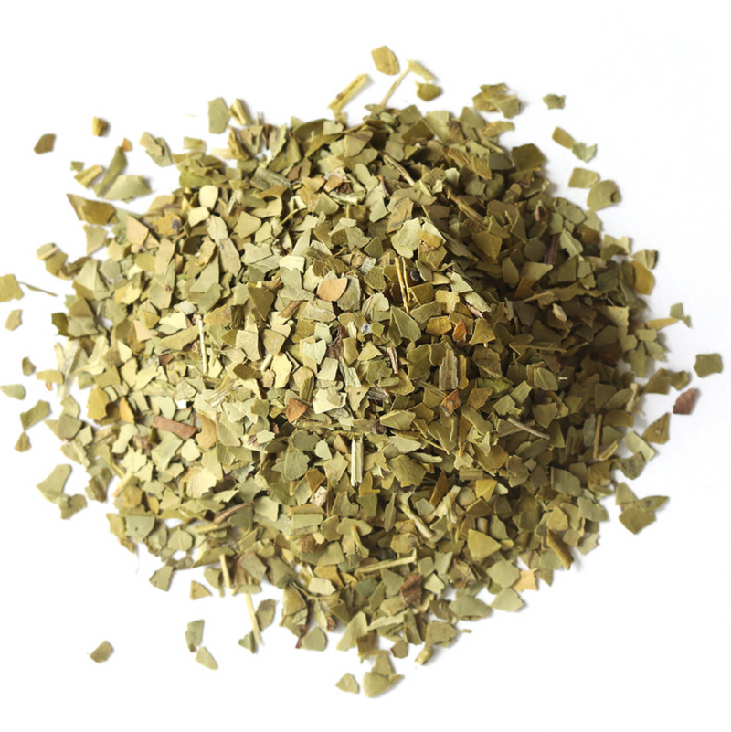 A pile of dried, chopped green Yerba Maté leaves from Mountain Rose Herbs on a white background, commonly used for making herbal tea.