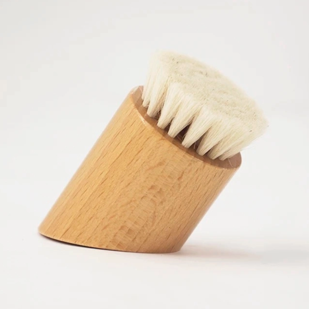 angular wood shaving brush standing up on white background