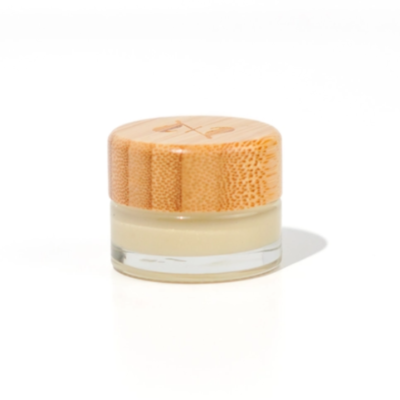 A small glass jar of Zerra &amp; Co. Vanilla Flavored Plant Based Jelly with a light wooden lid rests on a white surface. The jelly is sheer with a shimmer. 