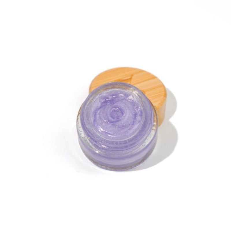 Small glass jar of the castor oil based plant based jelly in the flavor lavender lemonade. the jelly is a light purple with a shimmer to it. The jar has a bamboo lid and is on a white background.
