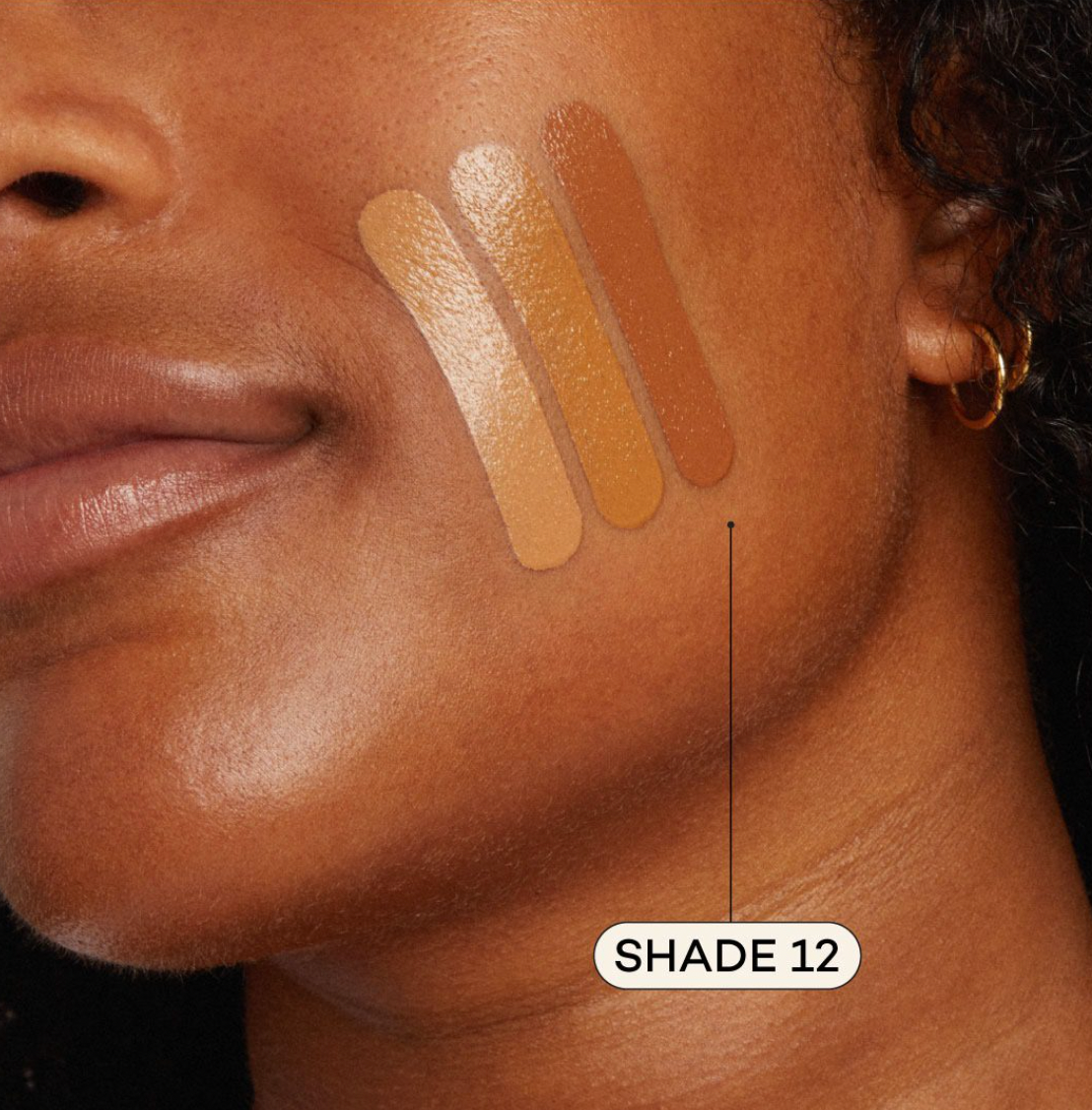 Medium dark skinned woman featuring medium foundation swatched on cheek