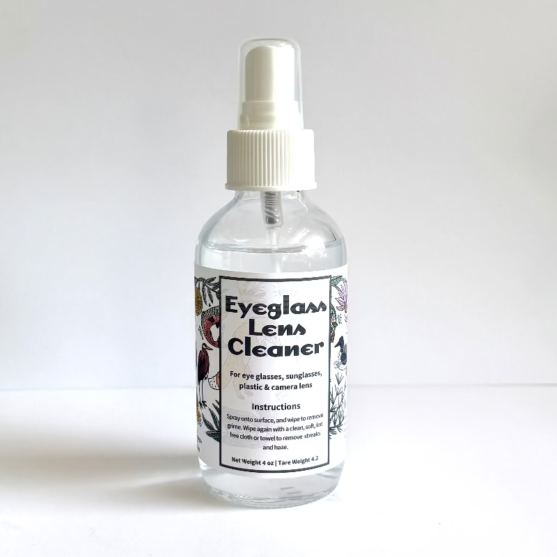 Bottle of eyeglass lens cleaner with a white label on a light gray background