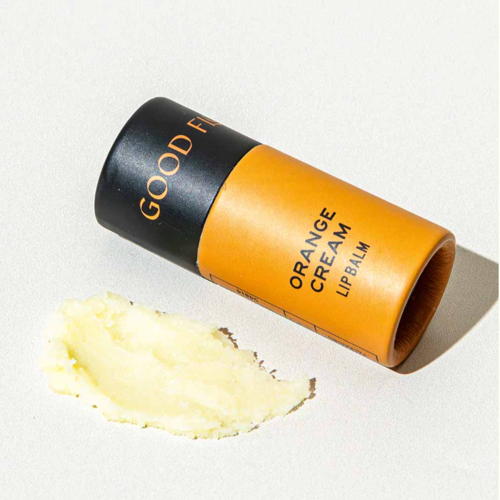 Good Flower Farm Orange Cream lip balm tube on a light background