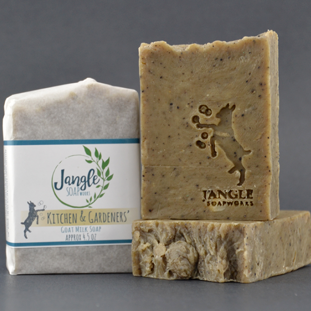 Jangle's Kitchen and Gardener's Soap. The brown bar is stamped with an image of a goat kicking bubbles. Two bars are unwrapped and one is upright on top of the other and the third bar is wrapped in paper. 