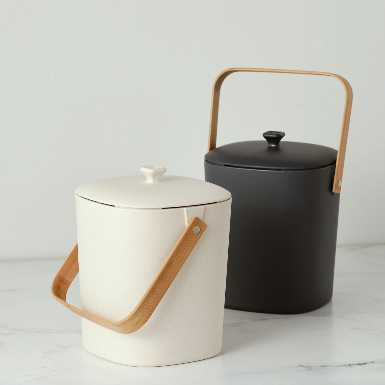 white and black bins with wood handle and lids on marble background