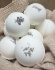 brown basket of white bath bombs with lavender buds on top