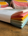 Set of folded colorful fabric swatches on a wooden surface