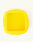 A bright yellow square-shaped silicone mold with rounded corners, shown from a top-down view on a clean white background.