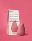 Pink solid conditioner bar with packaging on a pink background