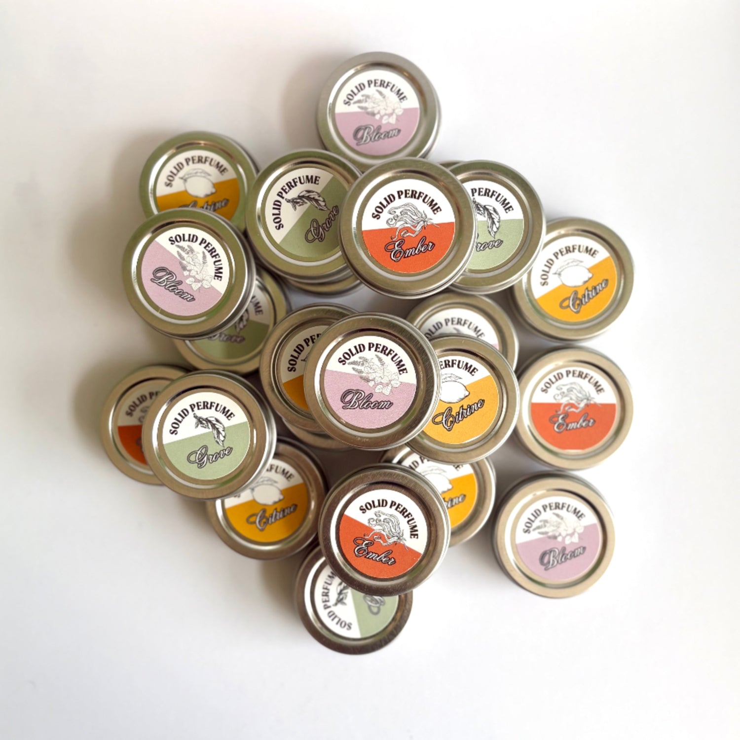 Collection of solid perfume tins with visible brand names on a white background