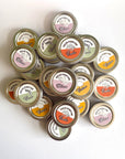 Collection of solid perfume tins with visible brand names on a white background