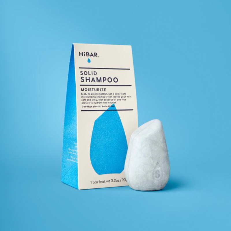 Solid shampoo bar with packaging on a blue background
