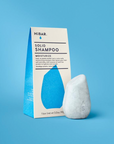 Solid shampoo bar with packaging on a blue background